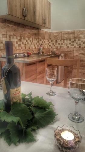 a bottle of wine sitting on a table with two glasses at Apartment Maša in Trebinje