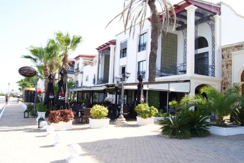a building on a street with palm trees and plants at Appartement Miradorgolf in Cabo Negro