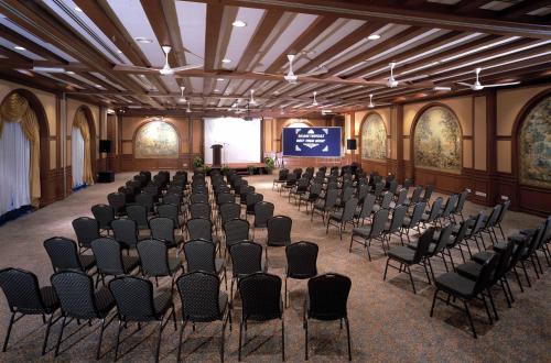 a room with rows of chairs and a stage in a building at Colmar Tropicale in Bukit Tinggi