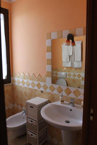 a bathroom with a sink and a toilet and a mirror at Palmas Dorada Home in Olmedo