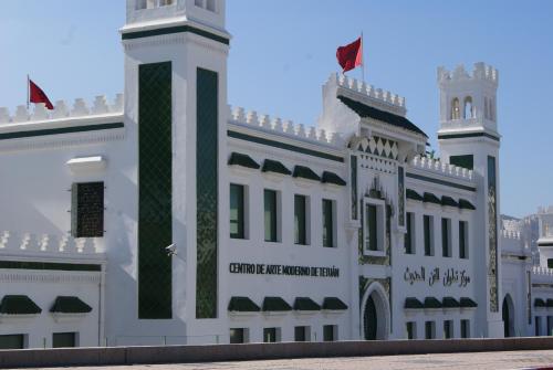 a white building with a flag on top of it at Appartement Miradorgolf in Cabo Negro