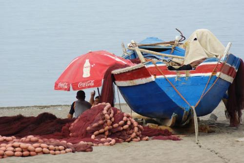a boat on the beach next to a pile of potatoes at Appartement Miradorgolf in Cabo Negro