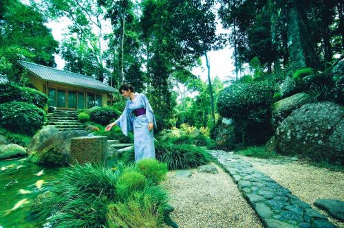 a man in a kimono standing in a garden at Colmar Tropicale in Bukit Tinggi