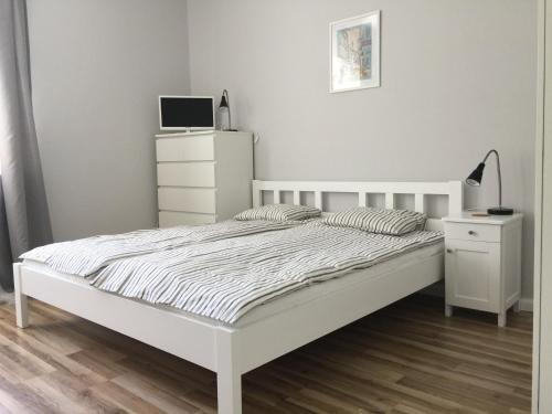 グディニャにあるApartament Warszawskaのベッドルーム(白いベッド1台、白いドレッサー付)