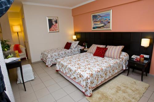a hotel room with two beds and a couch at Ionian Plaza Hotel & Spa in Argostoli