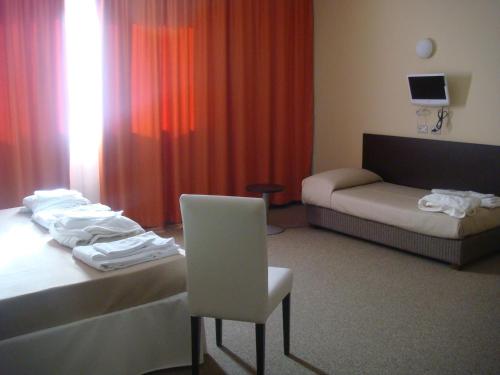a room with a bed and a chair and a couch at Santa Loja Hotel Residence in Tito