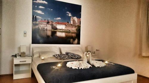 a bedroom with a bed with a painting on the wall at Apartment Maša in Trebinje