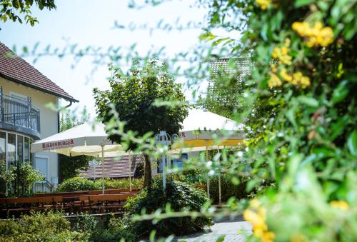 a patio with umbrellas in front of a building at Landhotel Schneider in Riedenburg