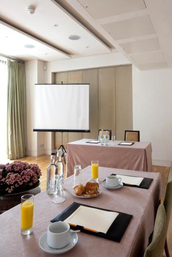 a conference room with a table with food and a screen at The Park City Grand Plaza Kensington Hotel in London
