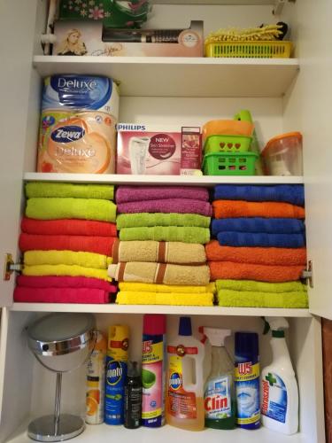 a closet filled with colorful towels and other items at Green Apartment in Odorheiu Secuiesc