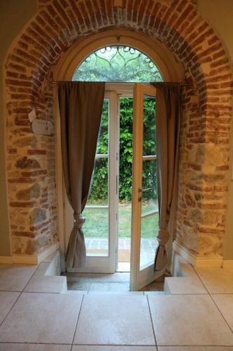 an arched entryway with a glass door and a window at La Piana in Monzambano