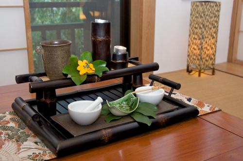 a tray with bowls and flowers on a table at Colmar Tropicale in Bukit Tinggi
