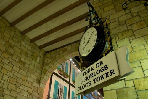 a clock hanging on the wall of a building at Colmar Tropicale in Bukit Tinggi