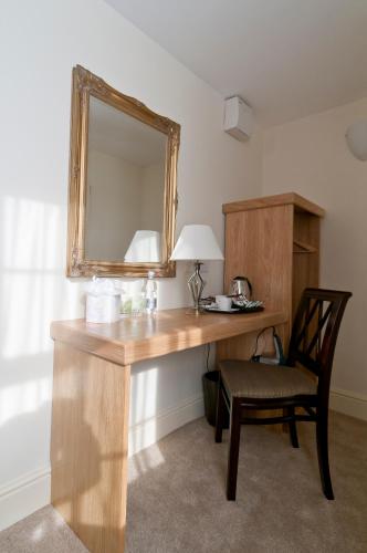 a wooden desk with a mirror and a chair at Castle Limes Hotel in Warwick