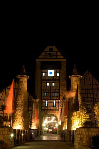 a large building with a clock tower at night at Colmar Tropicale in Bukit Tinggi