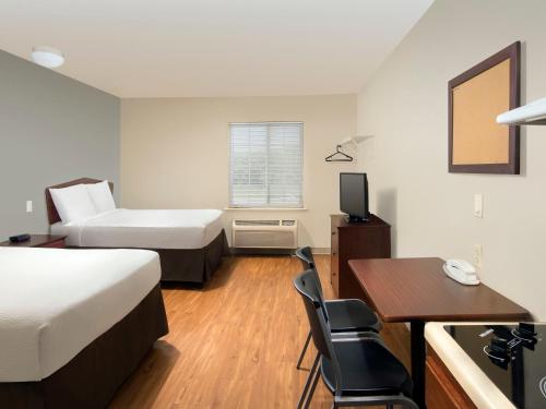 Ένα ή περισσότερα κρεβάτια σε δωμάτιο στο WoodSpring Suites Topeka