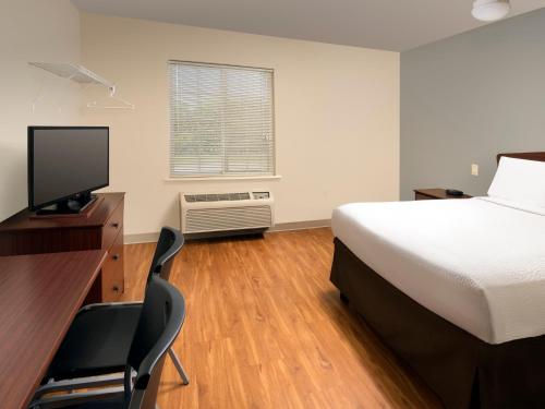 Ένα ή περισσότερα κρεβάτια σε δωμάτιο στο WoodSpring Suites Topeka