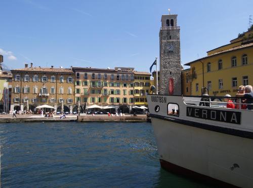 a boat in the water in front of buildings at Hotel Centrale in Riva del Garda