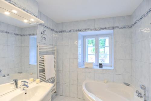 a white bathroom with a tub and a sink at Strict city apartments in Ljubljana