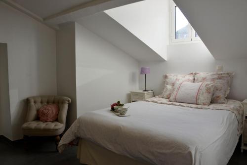 Un dormitorio blanco con una cama y una silla. en Cannes,croisette,palais des festivals,plages, en Cannes