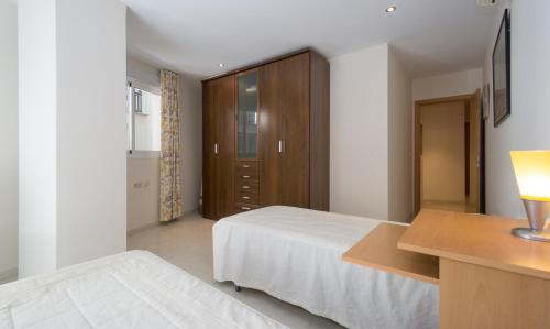 a bedroom with a bed and a desk and a cabinet at Plaza de las Flores in Málaga