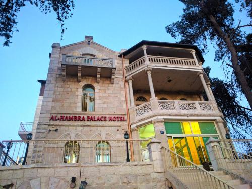 a building with a sign on the front of it at Alhambra Palace Hotel Suites - Ramallah in Ramallah