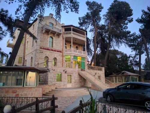 a house with a car parked in front of it at Alhambra Palace Hotel Suites - Ramallah in Ramallah