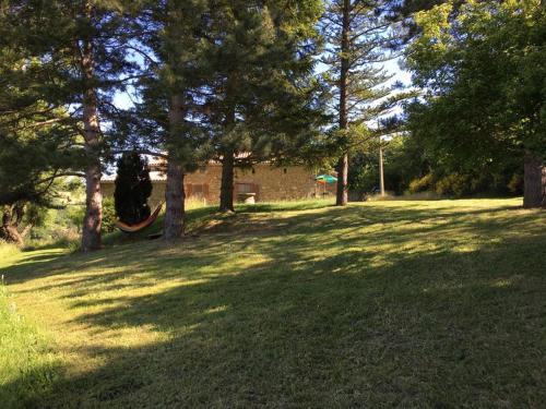 a large grass field with trees and a building at Weekend en Provence in Comps