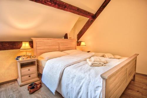 a bedroom with a large bed and a night stand at Hiša Linhart, Hotel & Restaurant in Radovljica