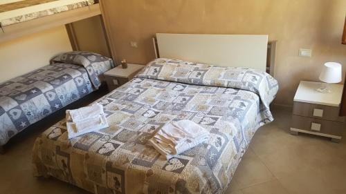 two beds in a room with two tables and a bed at Il Moro della Molpa in Palinuro