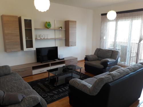 a living room with two couches and a flat screen tv at Villa Perlla in Split