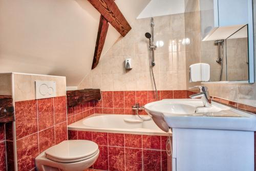 a bathroom with a toilet and a sink and a tub at Hiša Linhart, Hotel & Restaurant in Radovljica