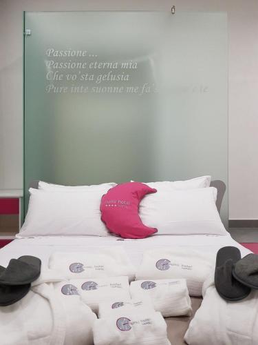 a bed with towels and hats on top of it at Hotel Nunù in Naples