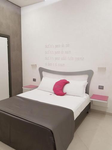 a bed with a red pillow on top of it at Hotel Nunù in Naples