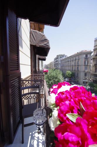 a balcony with pink and white flowers on a building at Hotel Nunù in Naples