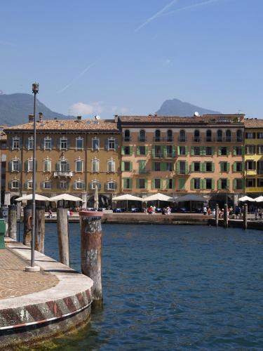 a large building next to a body of water at Hotel Centrale in Riva del Garda