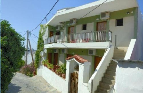 a white building with stairs and a balcony at Anais Studios in Patitiri