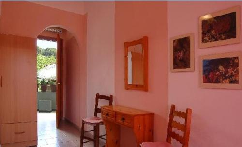 a room with a table and chairs and a mirror at Anais Studios in Patitiri