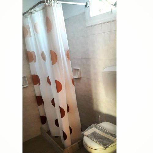 a bathroom with a shower curtain with a toilet at Studios Angela Village in Lipsoi