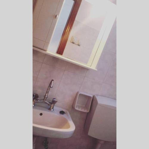 a bathroom with a sink and a toilet and a mirror at Studios Angela Village in Lipsoi