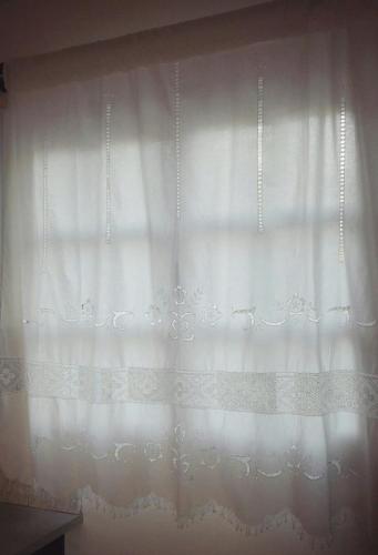 a white curtain on a window in a room at Studios Angela Village in Lipsoi