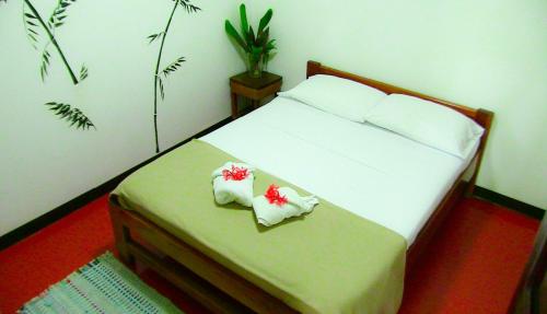 a bedroom with a bed with towels on it at Chosa Manglar Suites & Cabins in Puerto Jiménez