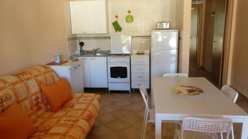 フルナリにあるCasa vacanze Portorosaのキッチン(ソファ、テーブル、冷蔵庫付)