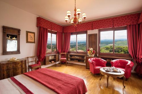 Schlafzimmer mit einem roten Bett, einem Tisch und Stühlen in der Unterkunft Residenza Fabroni in Montepulciano