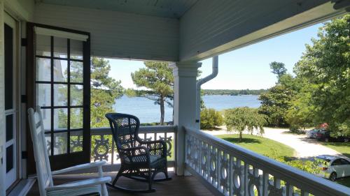 a porch with two chairs and a view of the water at Wades Point Inn on the Bay in Saint Michaels