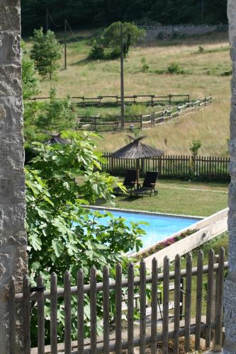 a fence next to a pool with a gazebo at Mas Manyaques in Le Tech