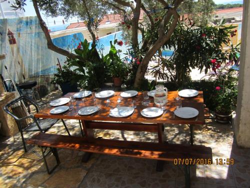 a wooden table with plates and glasses on it at Apartments Villa Bella Vista Hvar in Hvar