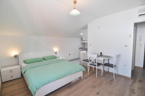 een slaapkamer met een bed en een tafel en stoelen bij Apartment Helen in Ičići