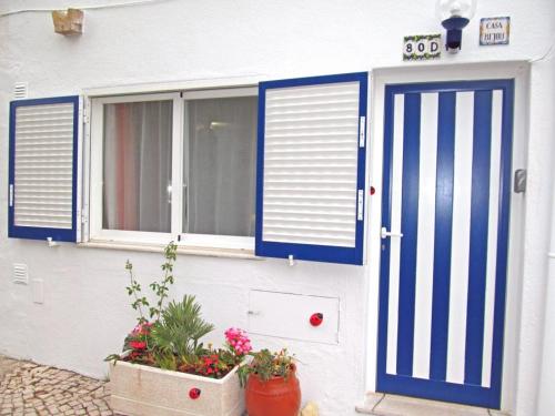 カルヴォエイロにあるMonte Carvoeiro Studioの青い扉と窓のある家