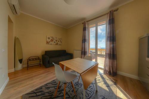a living room with a table and a couch at Hotel De La Plage in Pietra Ligure